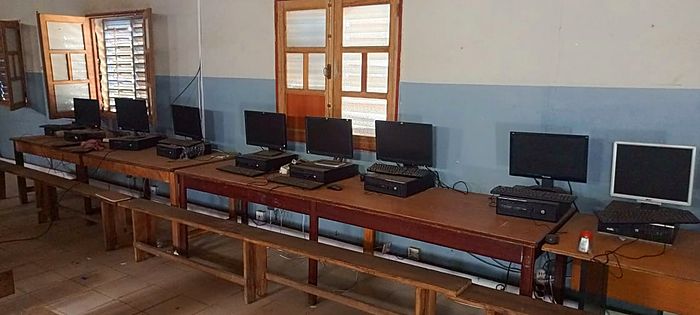 La salle informatique : ordinateurs alignés sur de longues tables en bois